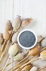 poppy seeds in a bowl on wooden surface