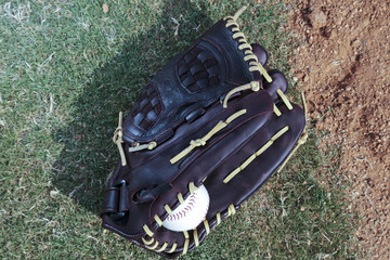 Baseball glove and ball with infield grass