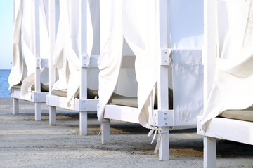 White wooden sunbeds on the beach, close up