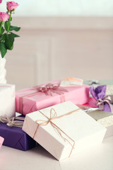 Composition of cute gift boxes and roses on white table