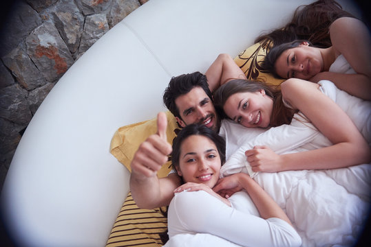 handsome man in bed with three beautiful woman