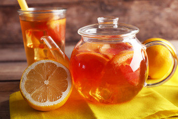 Iced tea with lemon and grapefruit on wooden background