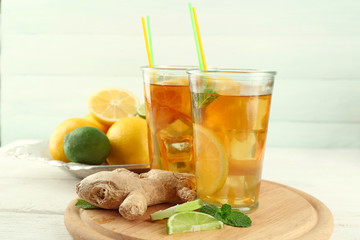 Iced tea with lemon on light wooden background