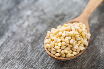 pine nuts in a wooden spoon