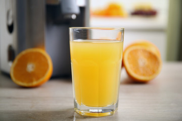 Juicer and orange juice on kitchen table