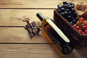 Bottle of wine and grape on wooden table