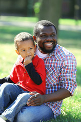 Father and son playing on grass in the park