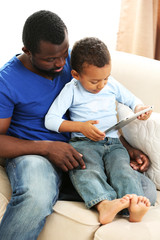 Father and son on sofa in the room