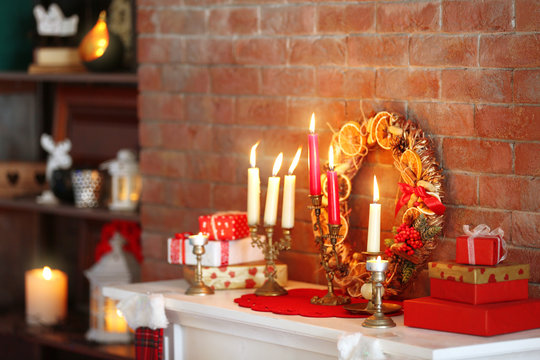 Christmas decorations and candles on mantelpiece