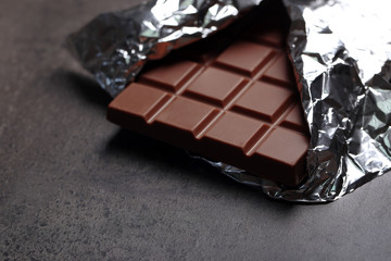 Chocolate bar in foil  on gray background