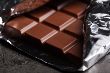 Chocolate bar in foil  on gray background