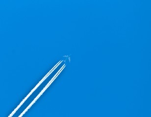 Closeup on airplane contrail against clear blue sky