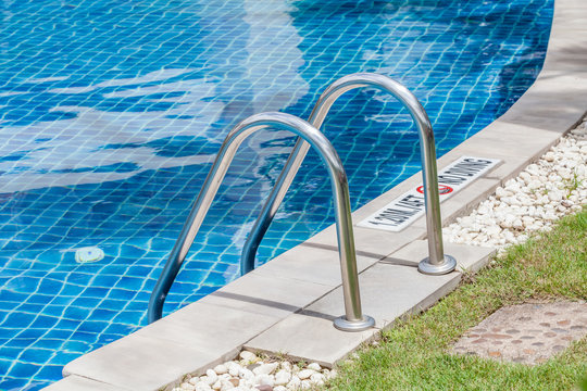 The metallic ladder for using entrance to swimming pool.
