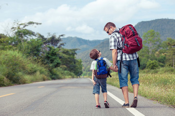 Father and son walking on the road.