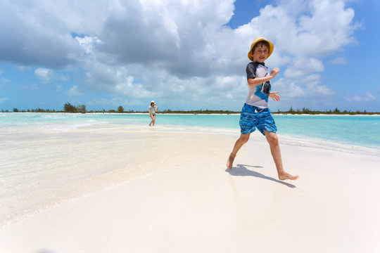 Stylish boy running on a tropical beach
