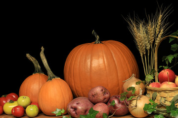 Thanksgiving garden vegetables displayed with wheat stalks. 