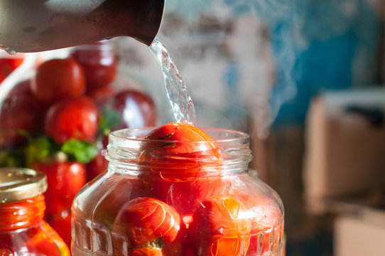 Tomatoes being swamped boiled water in process of canning