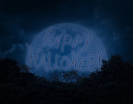 Halloween text over tree with dark sky and moon
