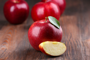 Red apples with leaf and slice on wooden table, closeup © Africa Studio