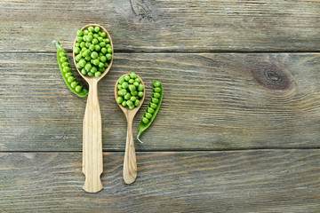 Fototapeta na wymiar Fresh green peas in wooden spoon on table close up