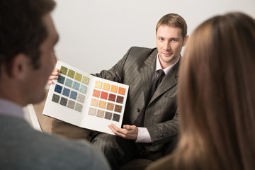 Architect shows wall color samples to young couple