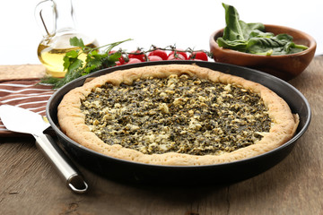 Open pie with spinach and tomato cherry on table close up
