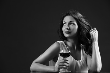 Pretty young woman with wineglass in shades of grey