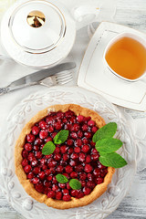 Tart with raspberries and tasty tea, on color  wooden background