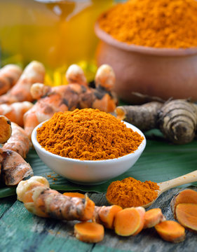 fresh turmeric roots on wooden table