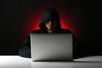 Hacker with computer and laptop on colorful dark background