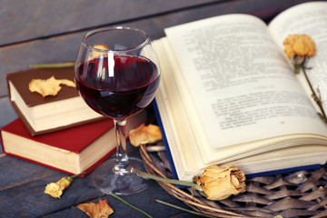 Beautiful composition with glass of wine with old books on table close up