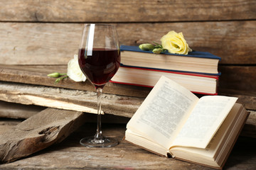 Beautiful composition with glass of wine with old books on table close up