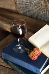 Beautiful composition with glass of wine with old books on table close up
