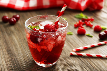Glass of berry juice on wooden table, closeup