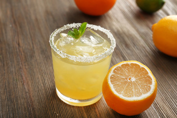 Glass of lemon juice on wooden table, closeup