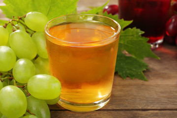 Glass of grape juice on wooden table, closeup