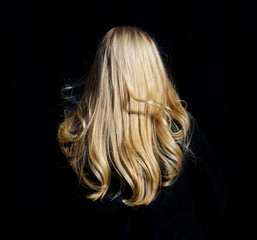 Naklejka premium Blonde woman walking on sidewalk. Only hair visible.