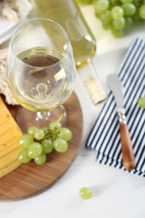 Still life of wine, grape, cheese and bread on light background