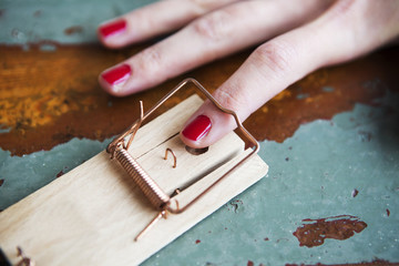 closeup of woman's finger in mousetrap