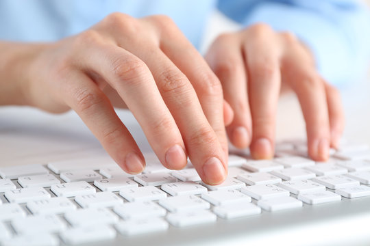 Female hands typing on keyboard close up
