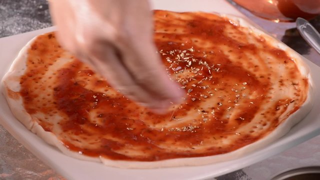 Housewife prepare pizza dough on glass table.