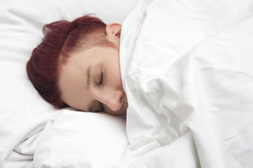 red-haired woman sleeping in bed