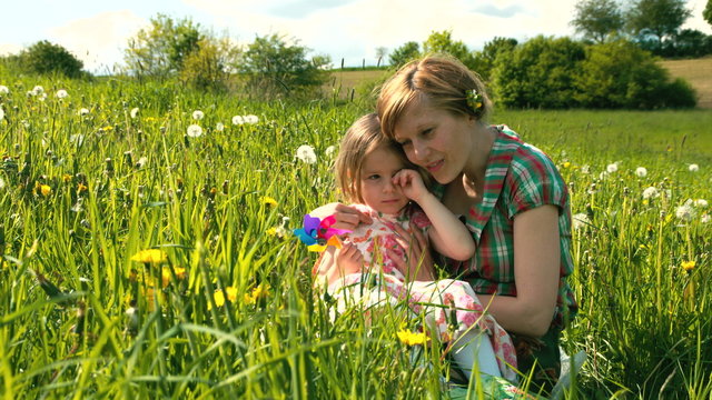 Die Mutter tr&ouml;stet ihre Tochter auf einer Fr&uuml;hlingswiese