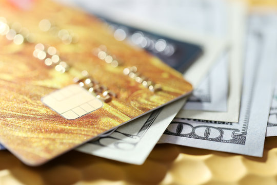 Credit cards and dollars on golden background