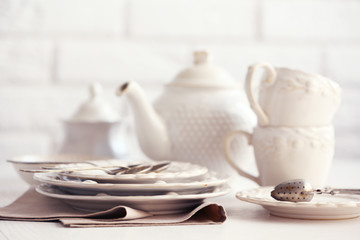 Clean dishes on table on brick wall background