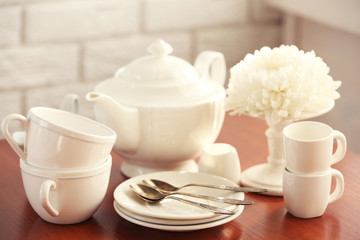 Clean dishes on table on brick wall background