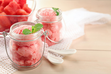 Watermelon ice cream in glass jars  on color wooden background