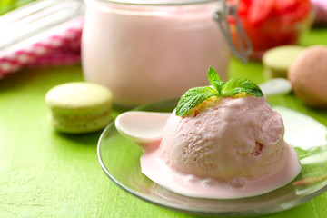 Watermelon ice cream in glass jar and on plate, on color wooden background