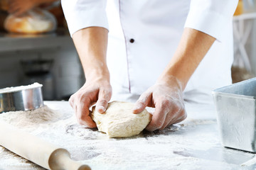 Making dough by male hands at bakery