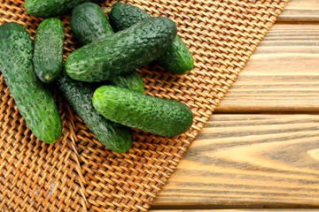 Fresh cucumbers on wicker wooden background